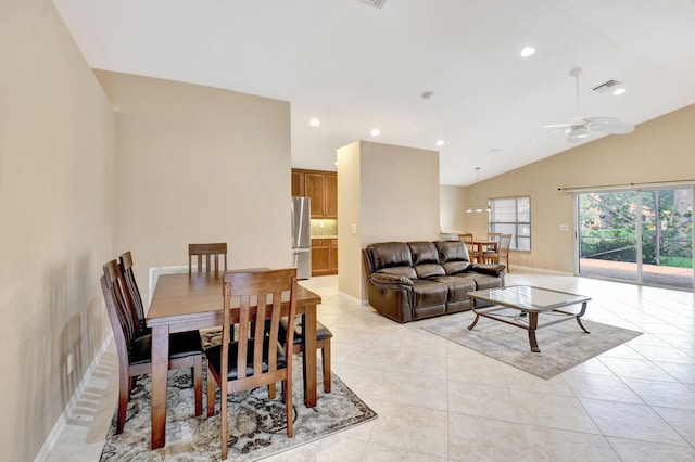 dining area with ceiling fan, vaulted ceiling, and light tile flooring