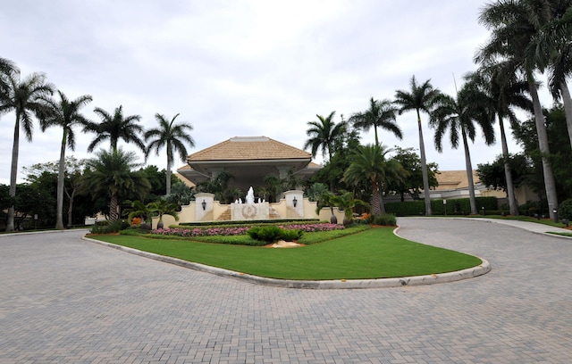 view of home's community with decorative driveway and a lawn