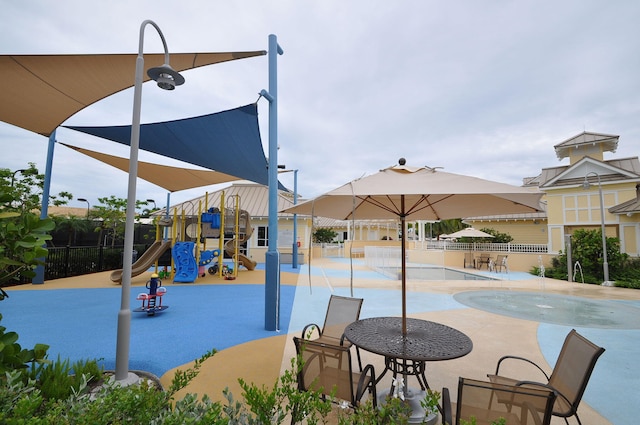 view of playground featuring a patio and a community pool