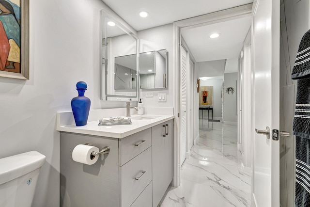 bathroom featuring tile flooring, vanity, and toilet