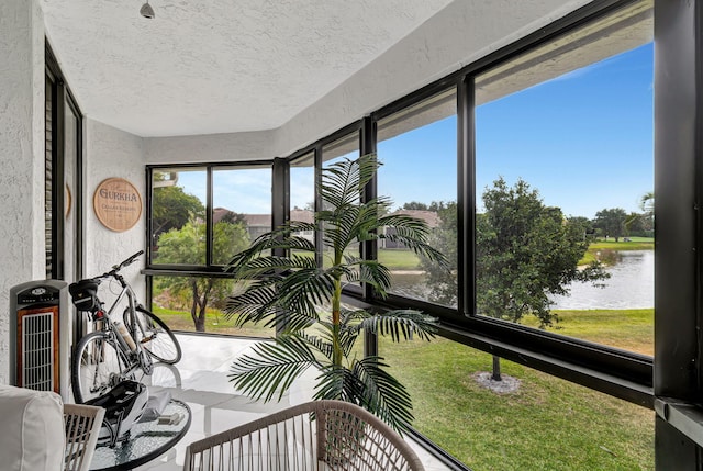 sunroom featuring a water view