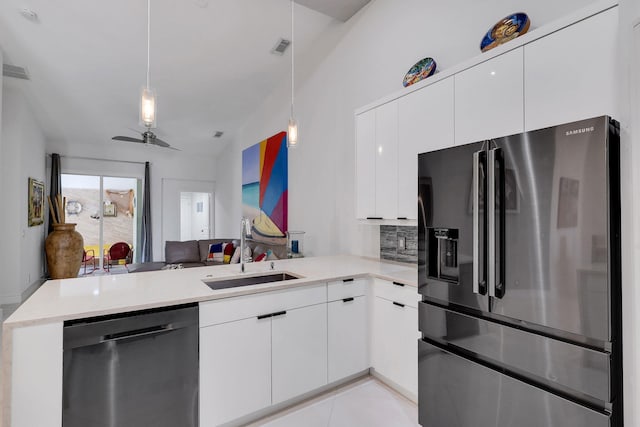 kitchen with pendant lighting, white cabinets, sink, appliances with stainless steel finishes, and kitchen peninsula