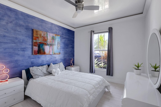 bedroom featuring ceiling fan, light wood-type flooring, and ornamental molding