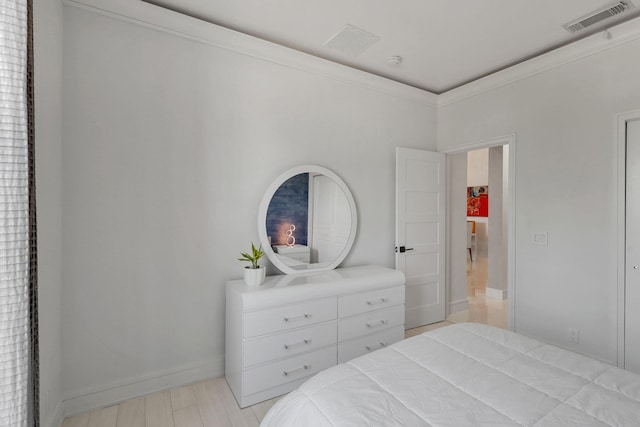 bedroom featuring light hardwood / wood-style flooring and crown molding