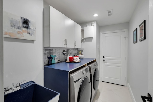 laundry area with washing machine and clothes dryer, sink, light tile patterned flooring, and cabinets