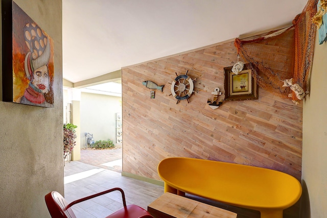 sitting room with wood walls and vaulted ceiling