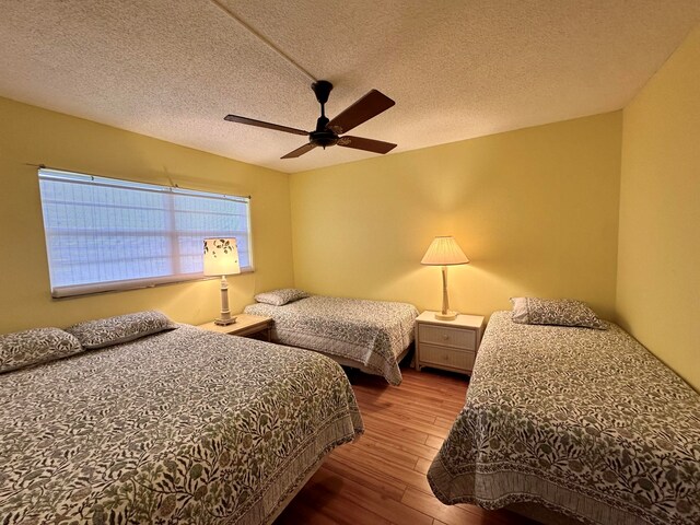 bedroom featuring ceiling fan, a textured ceiling, and wood-type flooring