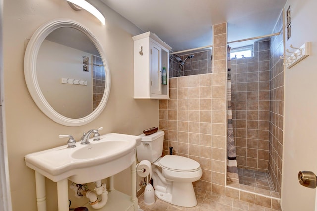 bathroom with a tile shower, tile flooring, and toilet