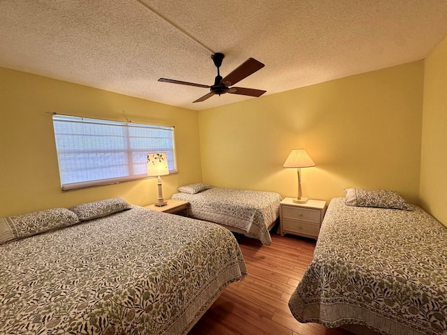 bedroom featuring wood-type flooring, ceiling fan, and a textured ceiling