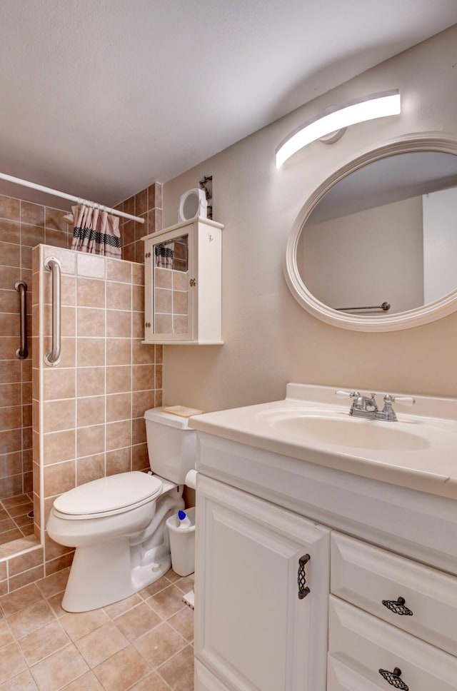 bathroom with tiled shower, tile floors, vanity, and toilet