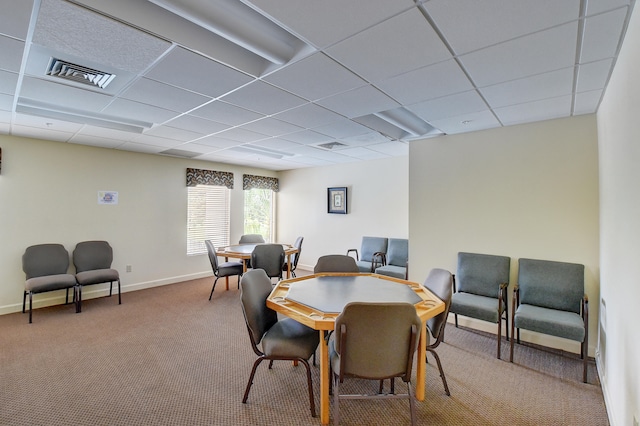 carpeted dining room with a drop ceiling