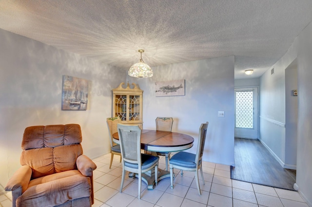 dining space with tile floors and a textured ceiling