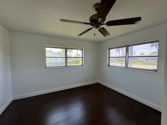 empty room featuring dark hardwood / wood-style flooring, plenty of natural light, and ceiling fan