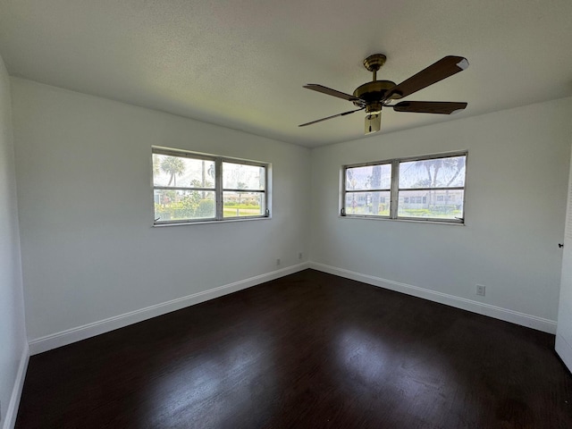 unfurnished room with plenty of natural light, ceiling fan, and dark hardwood / wood-style flooring