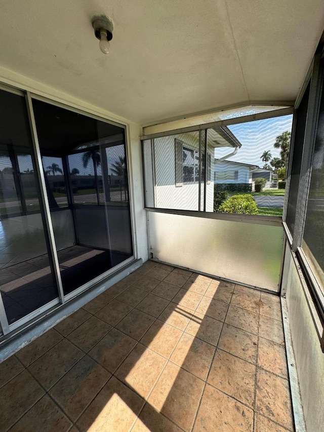 unfurnished sunroom featuring vaulted ceiling