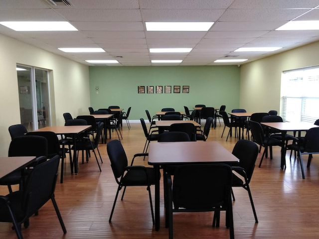 dining space featuring hardwood / wood-style flooring and a drop ceiling