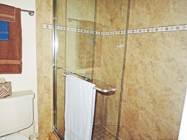 bathroom featuring an enclosed shower and toilet