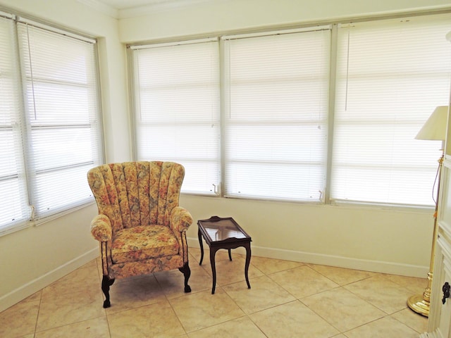 living area featuring light tile patterned flooring and ornamental molding