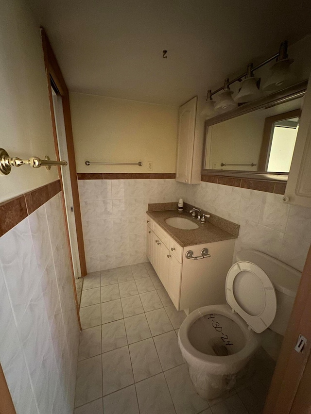 bathroom featuring vanity with extensive cabinet space, tile walls, toilet, and tile floors