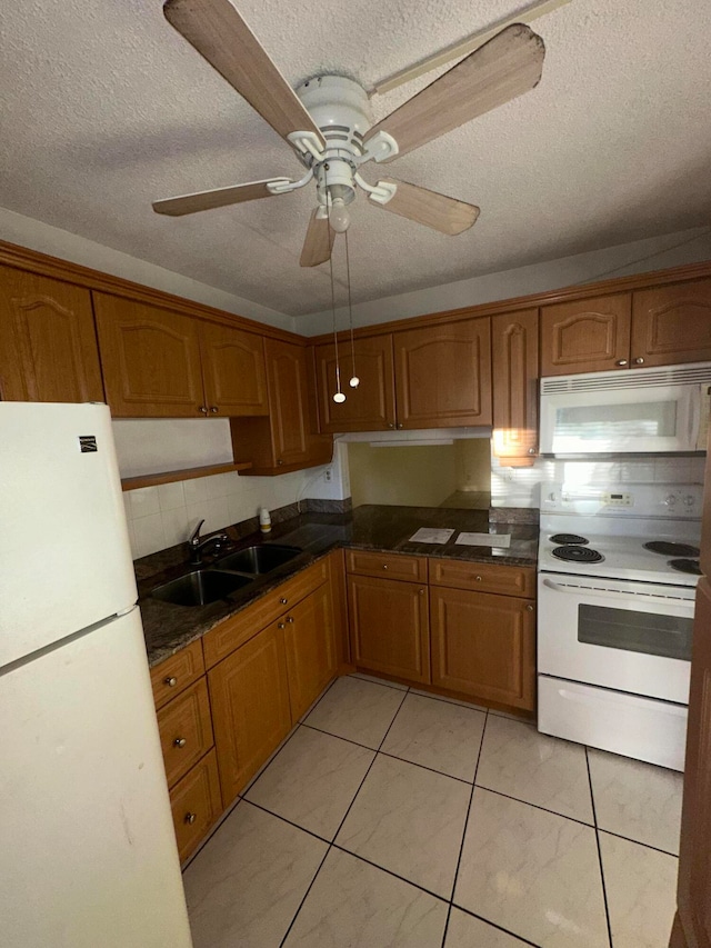 kitchen with a textured ceiling, white appliances, sink, ceiling fan, and light tile floors