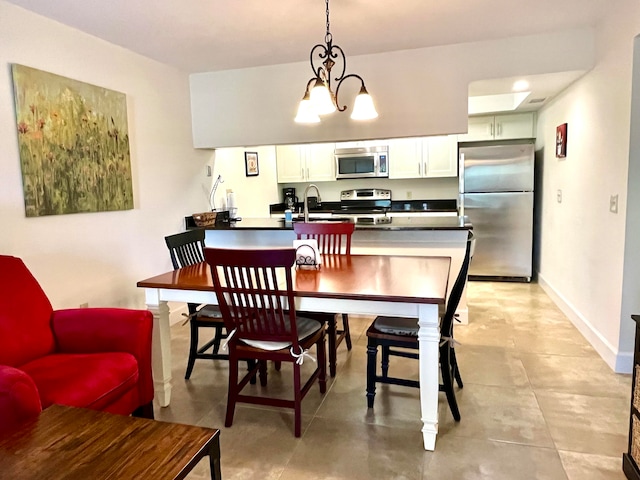 dining space with sink, a chandelier, and light tile floors