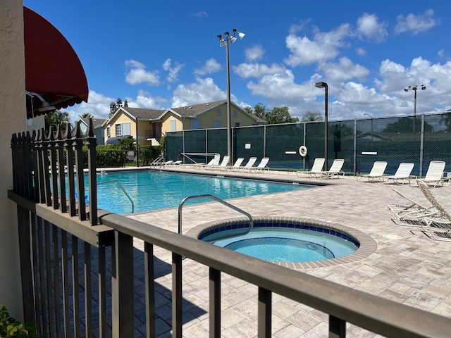 view of pool with a patio and a hot tub