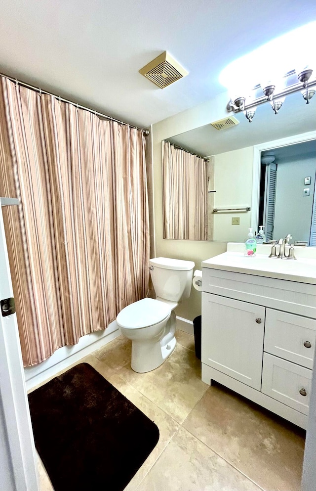 bathroom featuring tile flooring, oversized vanity, and toilet