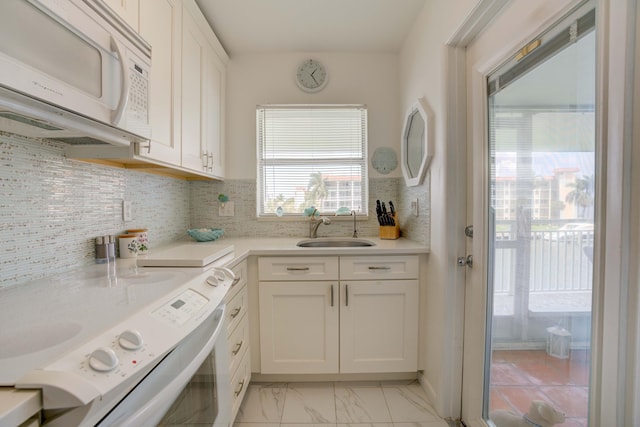 kitchen with white cabinets, decorative backsplash, white appliances, and sink