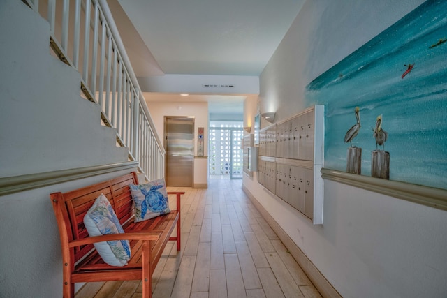 hallway with a mail area and hardwood / wood-style flooring