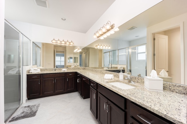 bathroom featuring an enclosed shower, vanity, a wealth of natural light, and tile patterned flooring