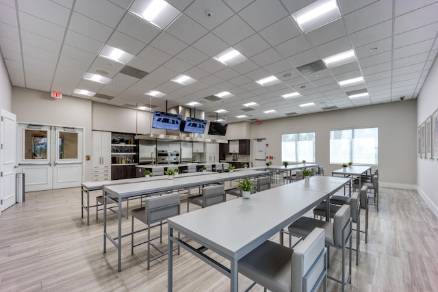 kitchen featuring a paneled ceiling, a spacious island, and a kitchen bar