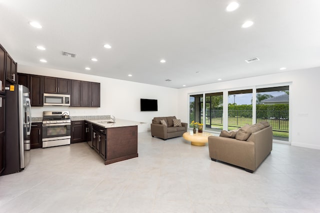 kitchen featuring dark brown cabinetry, sink, and appliances with stainless steel finishes