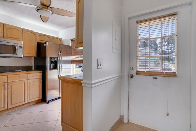 kitchen featuring appliances with stainless steel finishes, light brown cabinetry, ceiling fan, and light tile floors