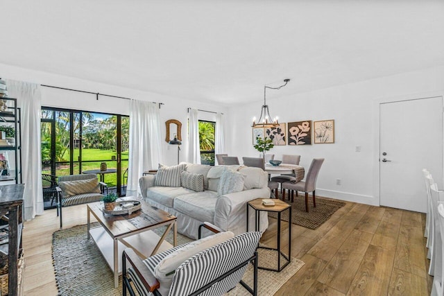 living room with light wood-type flooring and an inviting chandelier