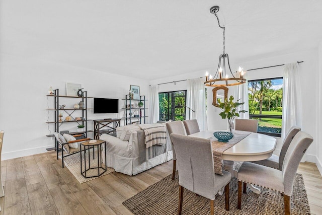 dining area with a chandelier, light hardwood / wood-style floors, and a wealth of natural light