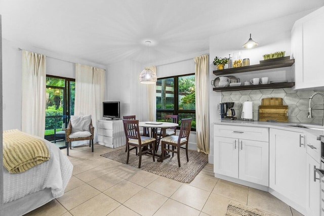 tiled dining space featuring plenty of natural light and sink