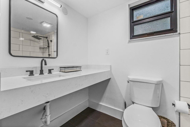 bathroom with tiled shower, sink, tile patterned flooring, and toilet