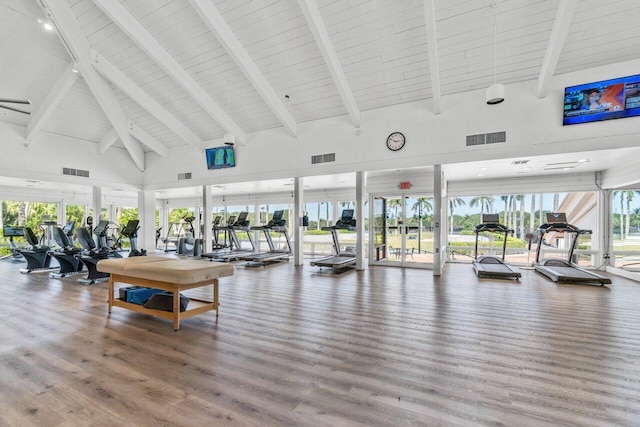 gym featuring hardwood / wood-style flooring, high vaulted ceiling, and french doors