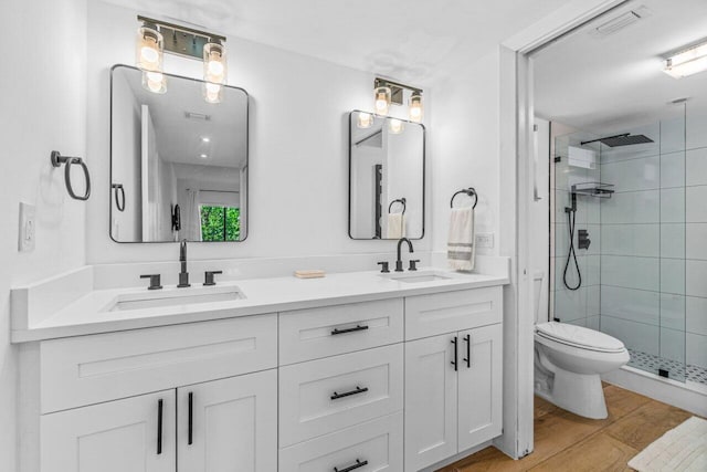 bathroom featuring vanity, wood-type flooring, an enclosed shower, and toilet