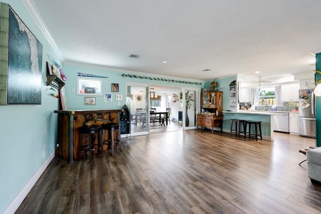 living room featuring wood-type flooring, ornamental molding, sink, and ceiling fan