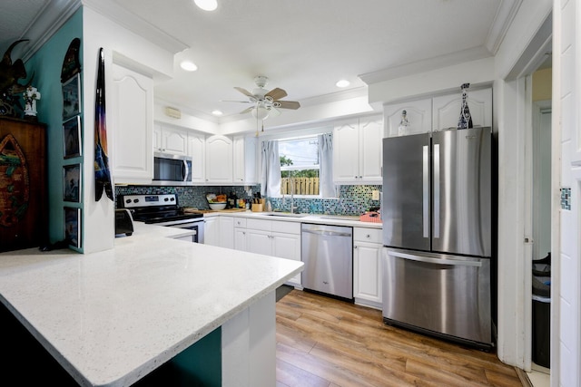 kitchen with ceiling fan, white cabinets, appliances with stainless steel finishes, and kitchen peninsula