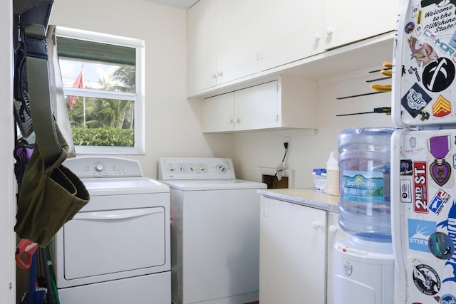 washroom featuring cabinets and independent washer and dryer