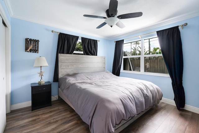 bedroom featuring multiple windows, crown molding, dark hardwood / wood-style flooring, and ceiling fan