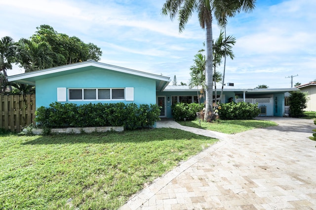 single story home featuring a front lawn and a carport