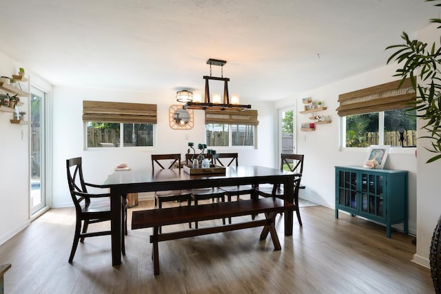 dining space with an inviting chandelier and dark hardwood / wood-style floors