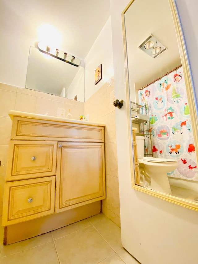 bathroom with tile flooring, tile walls, toilet, and vanity