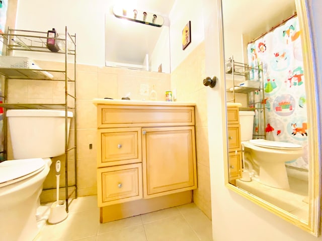 bathroom with tile flooring, tasteful backsplash, oversized vanity, tile walls, and toilet