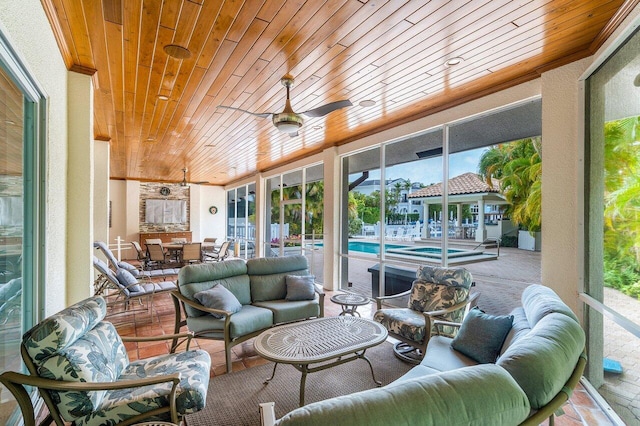 sunroom featuring ceiling fan and wooden ceiling