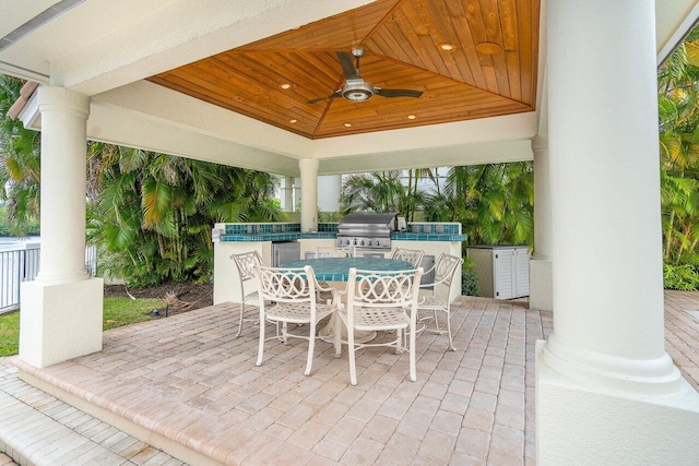 view of patio / terrace featuring a gazebo, ceiling fan, area for grilling, and exterior kitchen