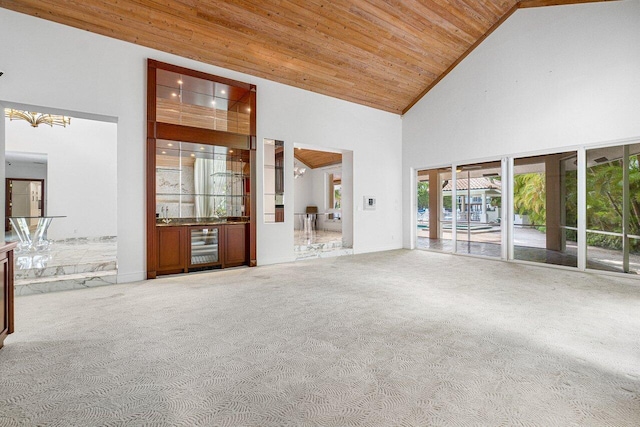 unfurnished living room with wooden ceiling, high vaulted ceiling, carpet floors, beverage cooler, and a chandelier